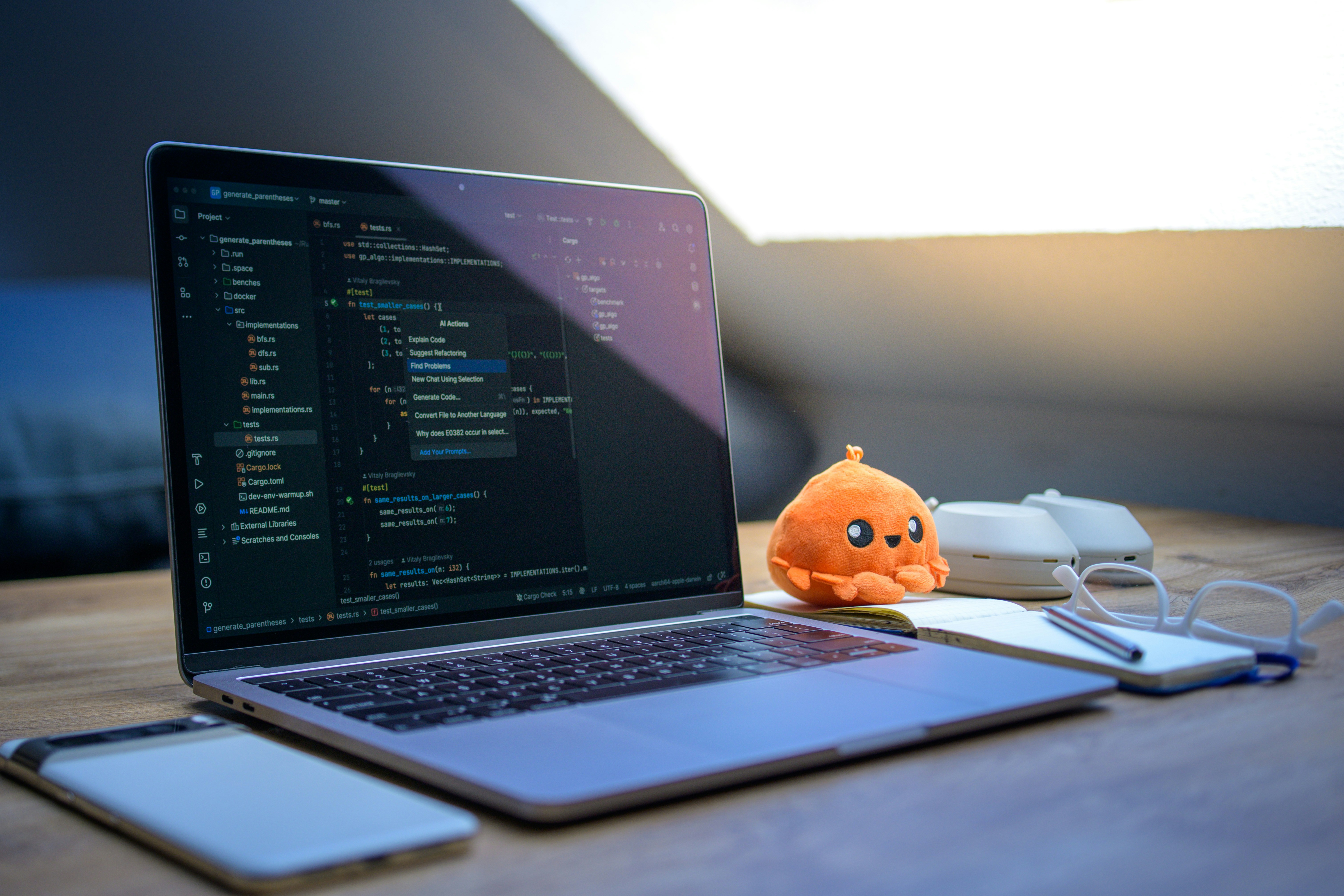Laptop displaying code editor with AI actions menu open, on a desk bathed in golden light